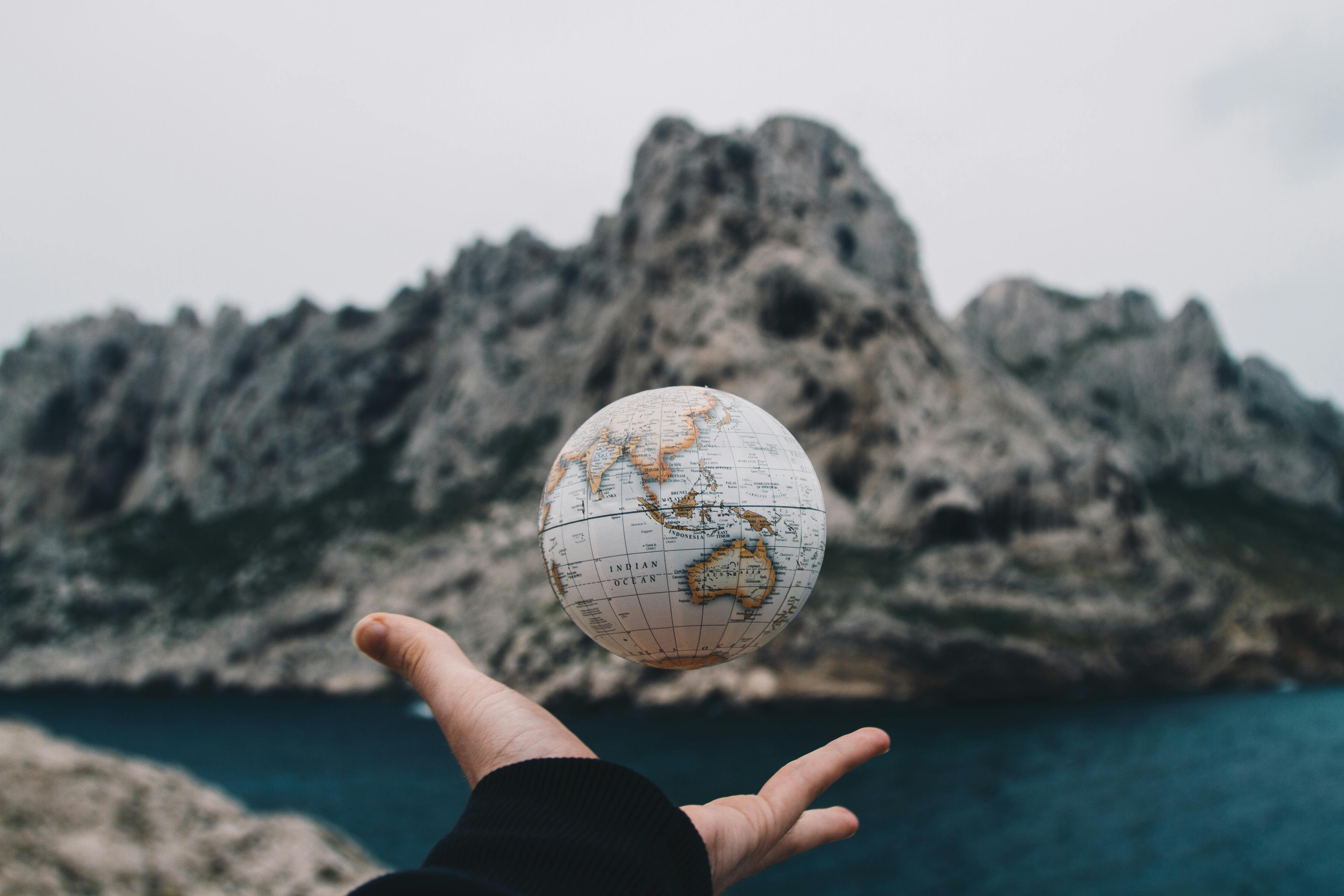 Photo of a mini globe mid-air after thrown from the hand.